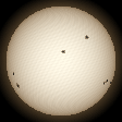 Rotating Sun with sunspots, brighter at the centre and redder at the edge